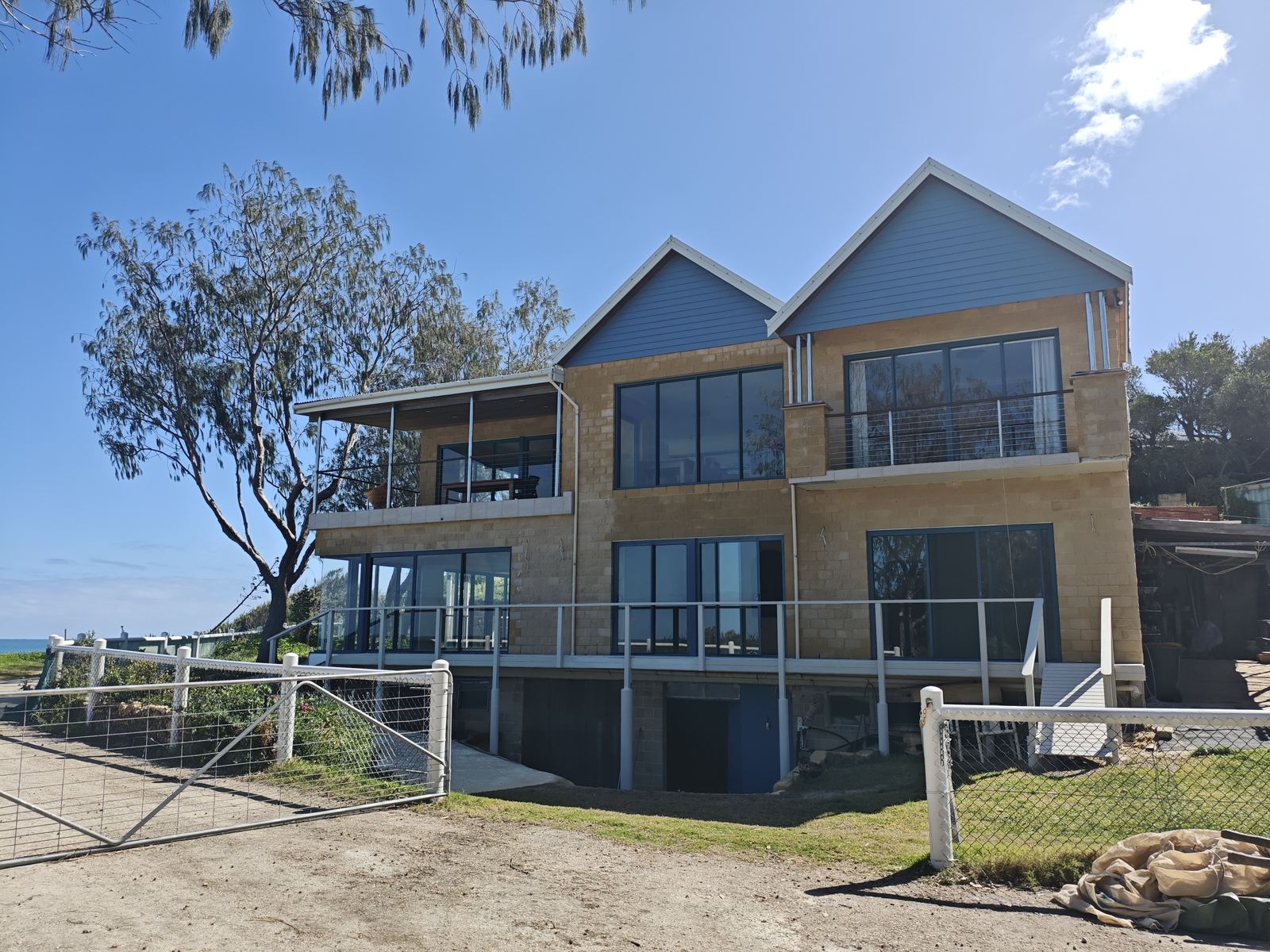 Two-storey Perth home inspected by Akaki, framed by native trees against a clear blue sky