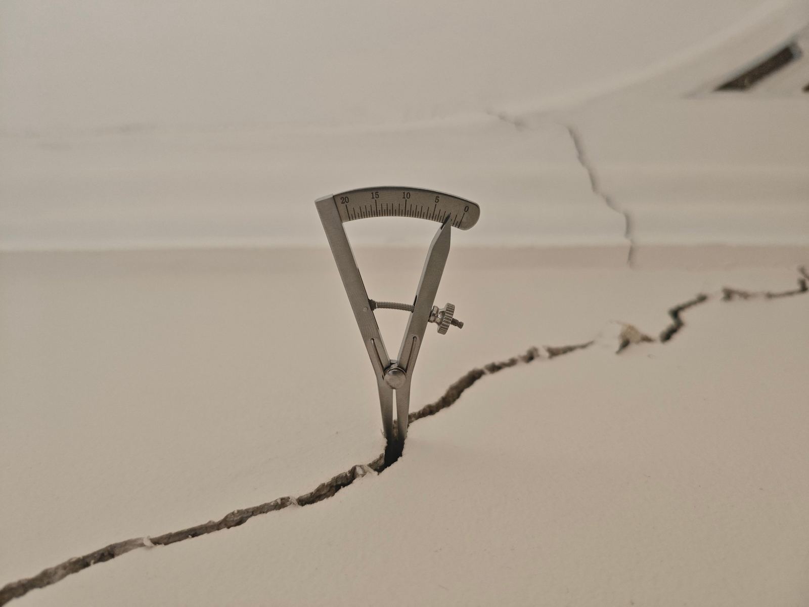Crack width gauge measuring a ceiling crack during a Dilapidation Survey