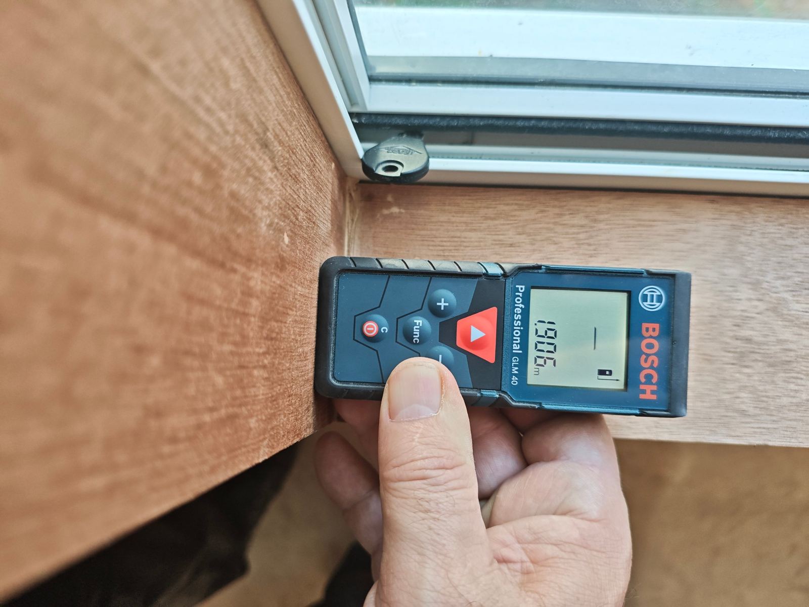 Laser distance measure used to check a window frame during a Specific Item inspection