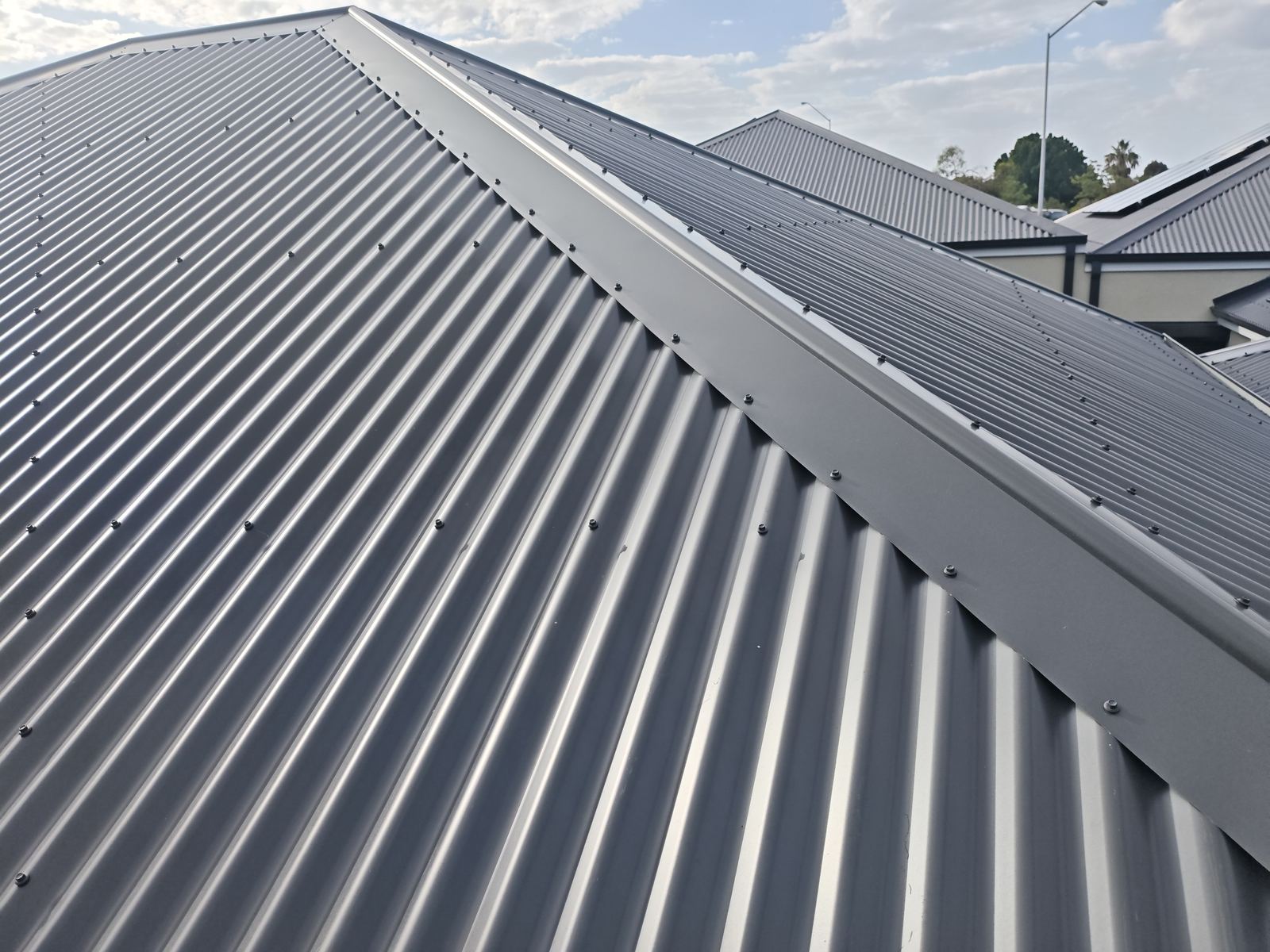 New metal roof sheeting checked during a practical completion inspection